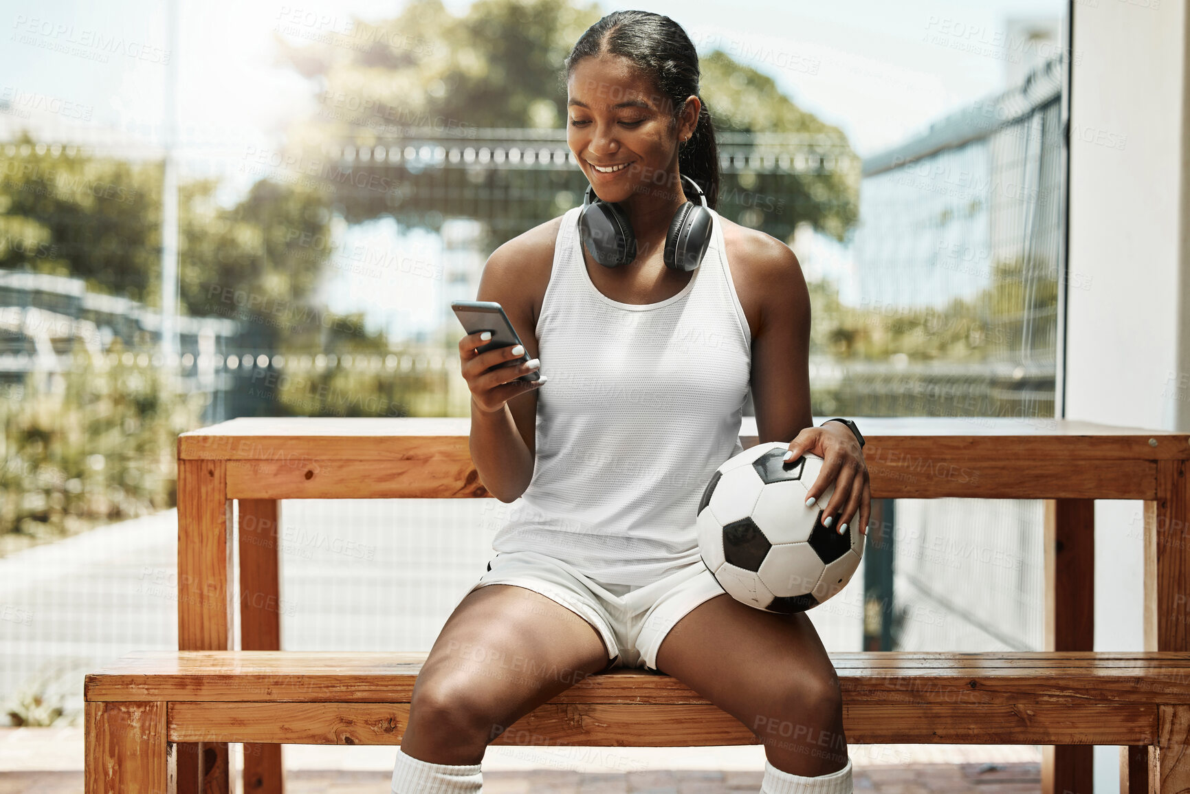 Buy stock photo Soccer, phone and black woman football athlete with a ball on sports rest after exercise and fitness. Training workout and game break of a healthy person smile using mobile technology and 5g internet