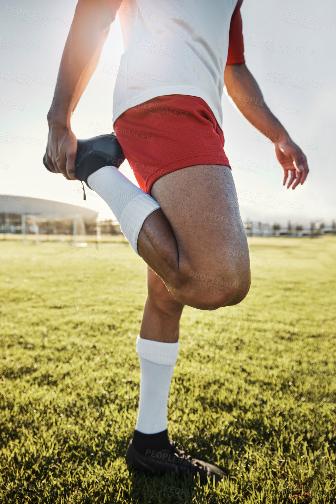 Buy stock photo Exercise, man and athlete doing stretching, prepare for training and practice for soccer game with workout in sportswear on field. Football, wellness and healthy male ready match, fitness and warm up