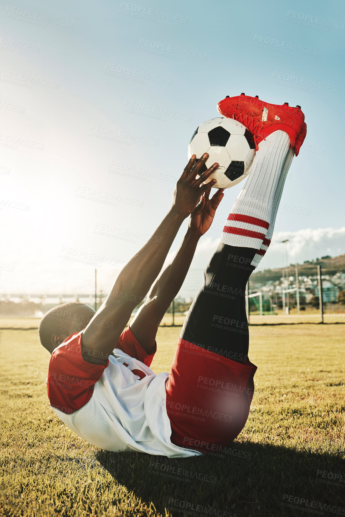 Buy stock photo Soccer, sports and stretching with a black man athlete training with a ball before a game or match outdoor. Football, fitness and workout with a male getting ready for sport on a grass pitch or field