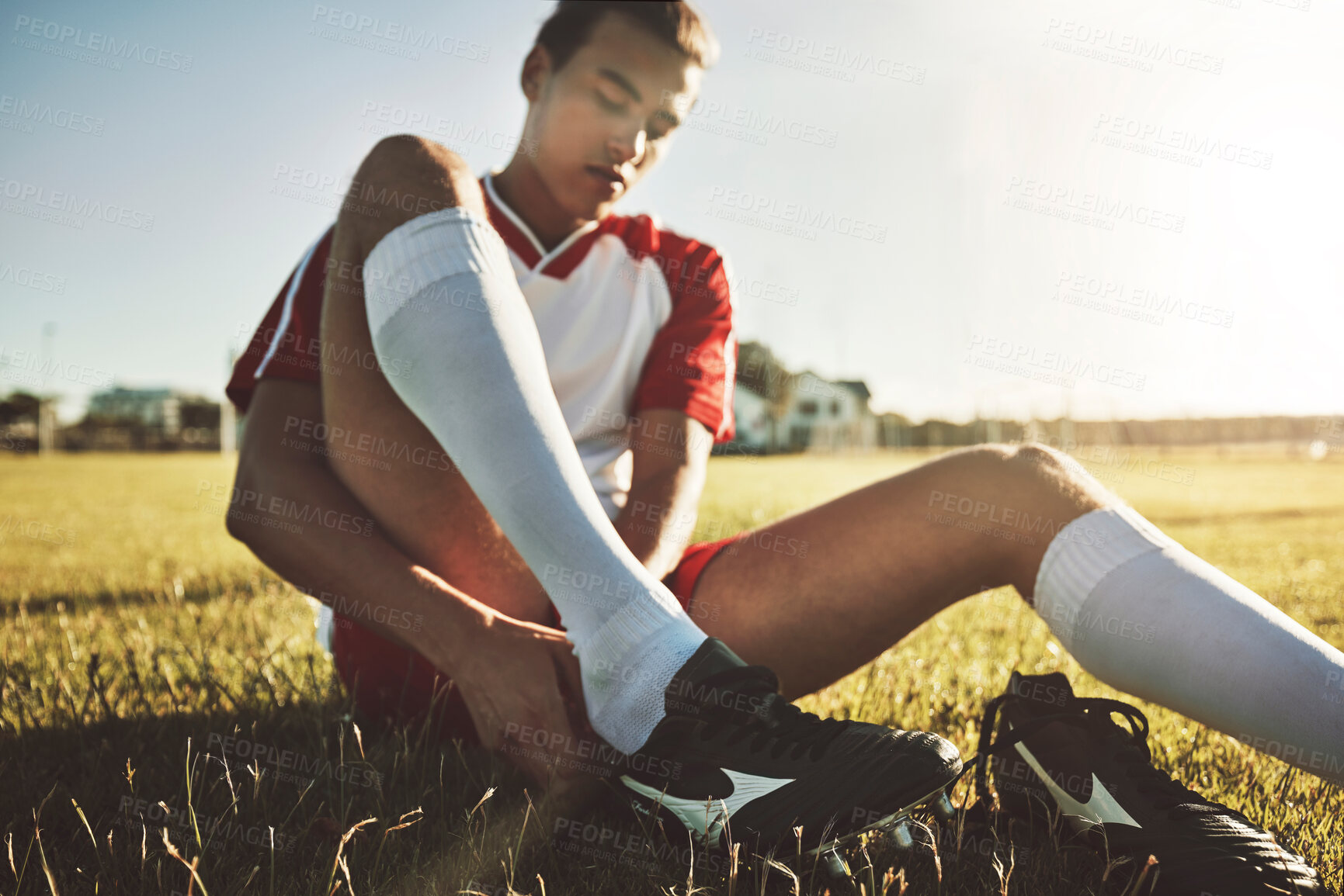 Buy stock photo Football, shoes and soccer player about to start fitness training, cardio workout and exercise on sports field. Athlete, Brazil and young man tying boots or footwear laces to get ready for practice