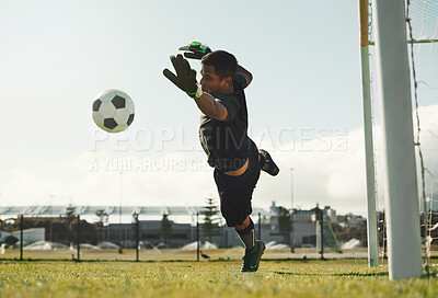 Soccer, goalkeeper and jump, saving ball from goals at outdoor sports field. Football, goalie and competition game with fitness, goal keeper and soccer ball on grass, success and mission to save goal
