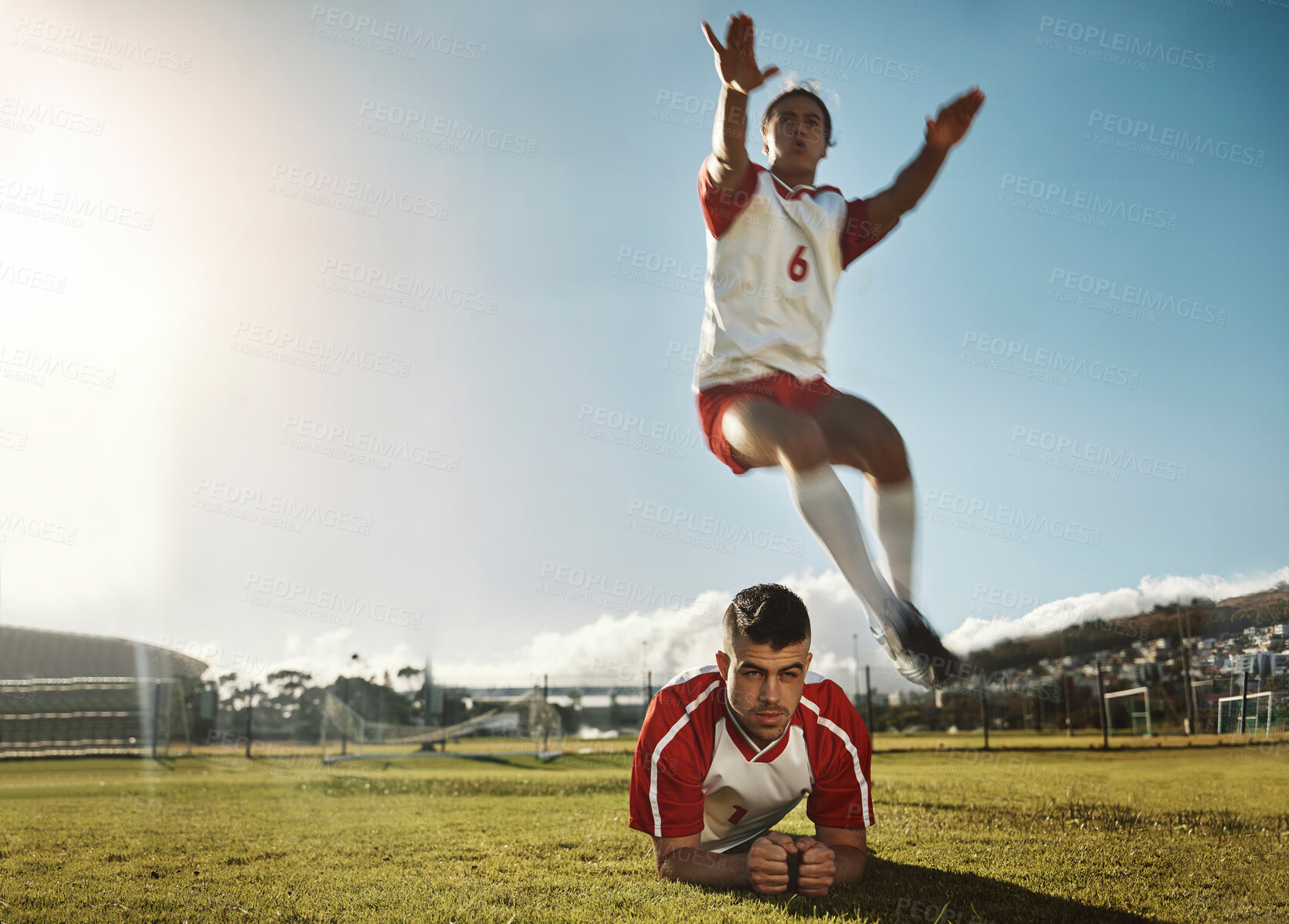 Buy stock photo Soccer, fitness and training with a sports man jumping over his teammate during practice on a grass pitch or field. Football, workout and exercise with a male athlete exercising with his team outdoor