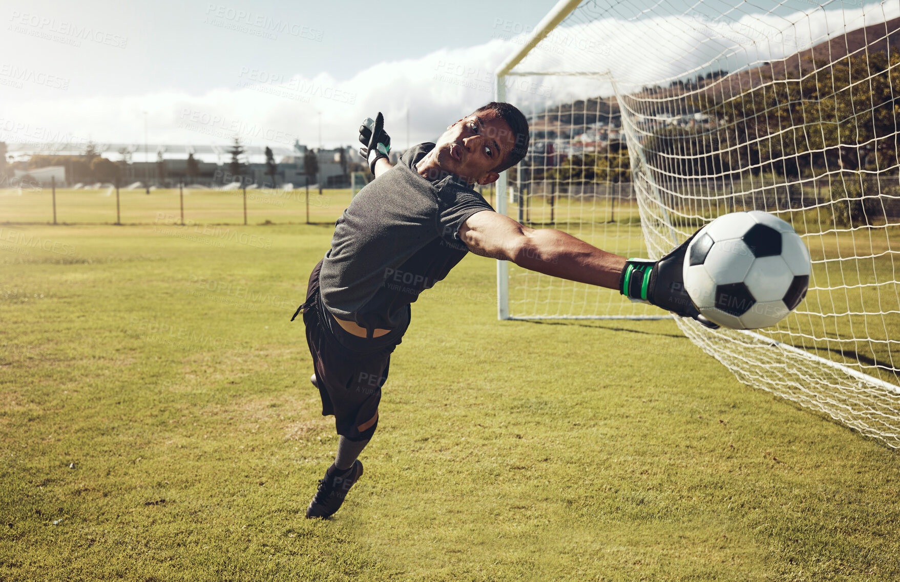 Buy stock photo Soccer, sports and goalkeeper training on a field for a professional competition. Young and strong athlete with energy and motivation catching a football during a game or exercise on a sport ground