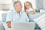 Laptop, elearning and senior family with child for online education, kids website communication and internet teaching at home on sofa. Grandfather and girl with technology play internet game together