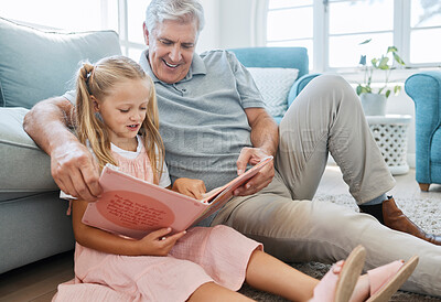 Buy stock photo Book, family and children with a girl reading to her grandfather on the floor of their living at home. Kids, read and story with a senior man and granddaughter bonding in their house during a visit