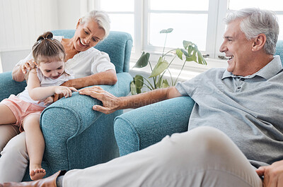 Buy stock photo Happy family, love and grandparents with child relax, bond and enjoy fun quality time together on home living room sofa. Young kid, senior grandfather smile and elderly grandma play with youth girl