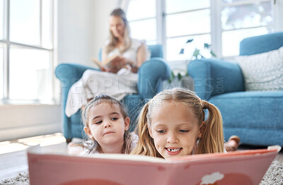 Buy stock photo Book, kids and family with a girl and sister reading while lying on the living room floor of their home together. 