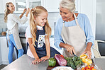 Learning, mother and grandmother cooking with girl teaching her a family recipe, vegetables and food diet. Smile, mom and senior woman love helping kid in the kitchen with child development at home