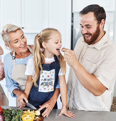 Buy stock photo Family, tomato and feeding with a girl and father eating a vegetable in the kitchen of their home together. Food, love and health with a man giving his daughter a healthy snack while cooking inside