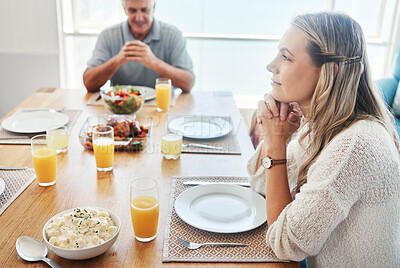 Buy stock photo Woman, thinking at the dinner table in gratitude for food, family and home. Female sitting in thought with father in hope, spiritual and religion for grateful thanksgiving meal together