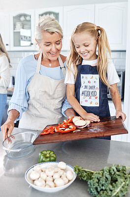 Buy stock photo Cooking, child and grandmother teaching a girl our to cook healthy food with nutrition in the kitchen of their house. Happy, smile and young kid learning about vegetables with an elderly woman 