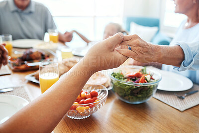 Buy stock photo Christian, family and pray for food holding hands for lunch together at home dining table. Faith, gratitude and prayer of thanks to God for meal with young and senior relatives in house.

