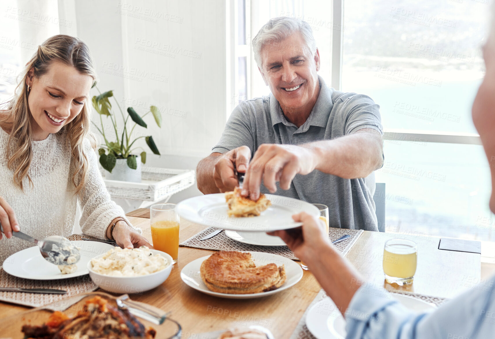 Buy stock photo Family, food and lunch with a senior man sharing a meal with his daughter in the dining room of their home during a visit. Retirement, love and eating with an elderly male pensioner and relatives