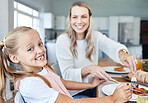 Food, family and mother and daughter eating at a kitchen table, happy, relax and bonding in their home. Love, portrait and girl learning etiquette, nutrition and sharing meal with a cheerful parent 