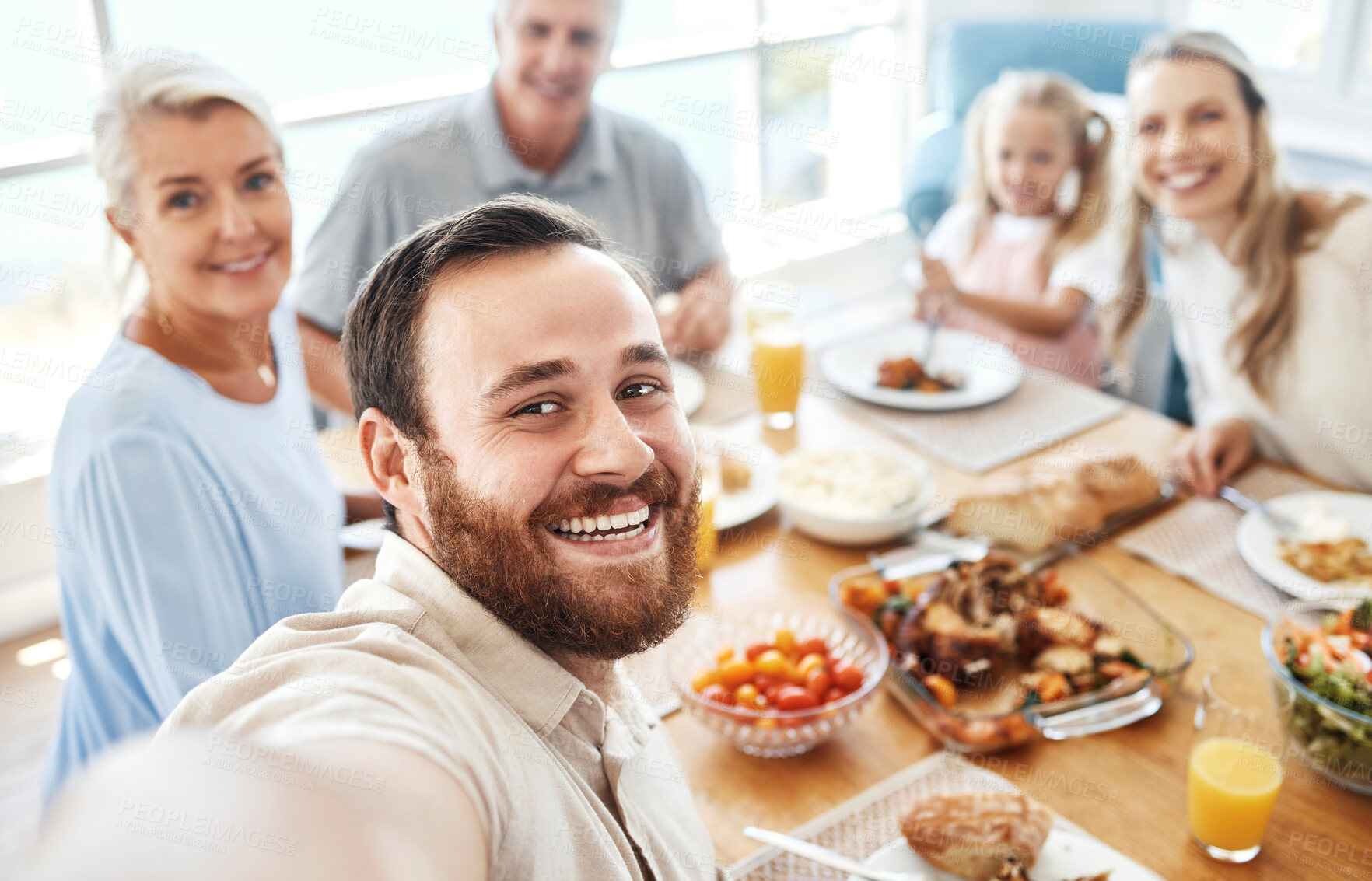 Buy stock photo Selfie, lunch and big family eating food together for celebration, love and care at the dining room table of their house. Portrait of young man with photo of his parents, child and wife at breakfast
