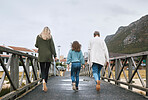 Family, walking and bridge in nature by mountain together on holiday, vacation and relax. Group, people and walk for bonding, time and love with kid, mother and grandmother on travel to Norway