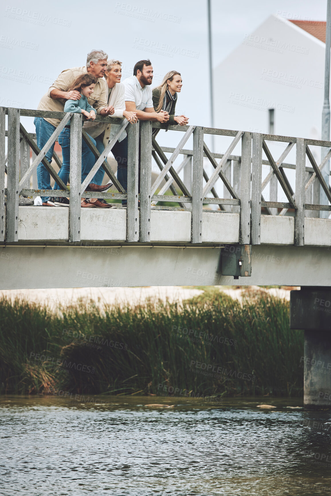 Buy stock photo Family, happy and bridge while standing by river together on holiday, vacation and relax in nature. Group, people and water for bonding, time and love with kids, parents and grandparents in Norway