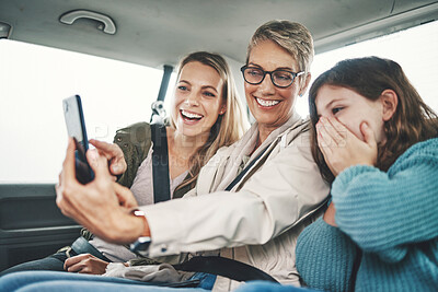 Buy stock photo Family, phone and women taking a selfie in the car on road trip adventure. Grandmother, mom and girl smile for picture on smartphone in backseat for memories of holiday, journey and vacation weekend