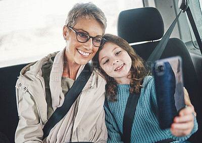 Buy stock photo Grandmother, girl and selfie with phone in a car while on a road trip for social media post online. Senior woman and kid smile, photo and happy with travel holiday with 5g smartphone in Germany 