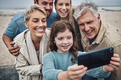 Buy stock photo Family, girl and phone selfie on beach holiday adventure spending time with parents and grandparents. Men, women and child smile in Australia, happy fun on winter hike by sea and photo on smartphone