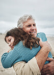 Happy, beach and grandfather hug a girl at the sea together on holiday. Happiness, love and elderly man in retirement smile, embracing and bonding with his toddler grandchild or kid on vacation
