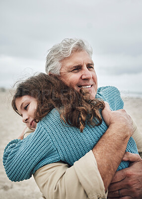 Buy stock photo Happy, beach and grandfather hug a girl at the sea together on holiday. Happiness, love and elderly man in retirement smile, embracing and bonding with his toddler grandchild or kid on vacation
