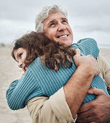 Buy stock photo Family, children and hug with a girl and grandfather embracing on the beach outdoor during a holiday or vacation. Travel, kids and love with a senior man thankful for his granddaughter by the sea