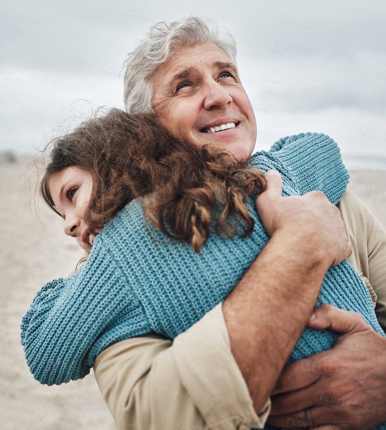 Buy stock photo Family, children and hug with a girl and grandfather embracing on the beach outdoor during a holiday or vacation. Travel, kids and love with a senior man thankful for his granddaughter by the sea