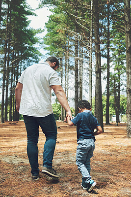 Buy stock photo Father, child and hold hands on walk in forest, nature or woods together for adventure. Man, dad and kid by trees, sunshine and earth for walking, bonding and happiness on vacation in summer with boy