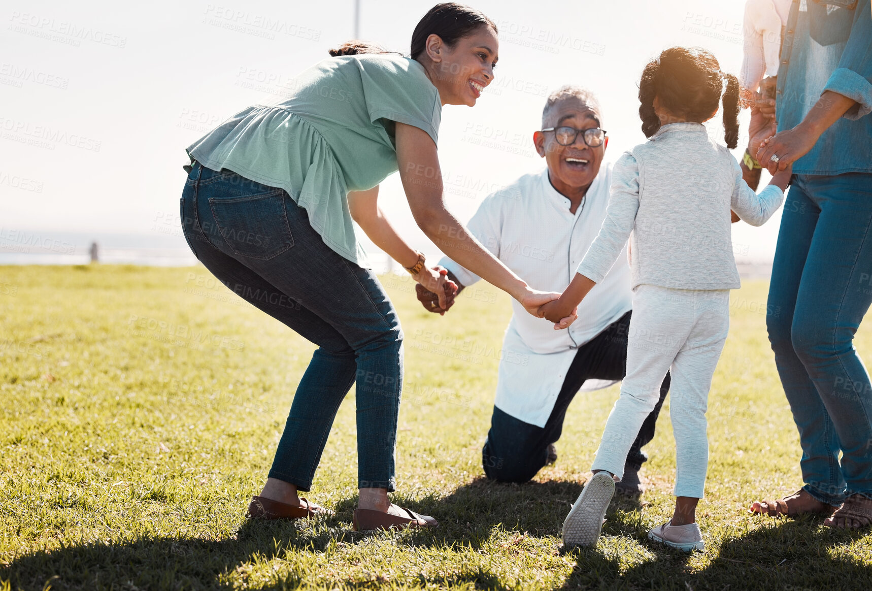 Buy stock photo Senior man, child and mother being outdoor, play and have fun while on seaside holiday, vacation and travel in summer. Mama, daughter and on field holding hands in circle, smile and happy together.