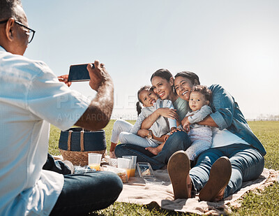 Buy stock photo Family, phone and picnic photo with smile, hug and happy together in summer on grass in park. Grandparents, mother or children with smartphone picture, social media and online during break on weekend