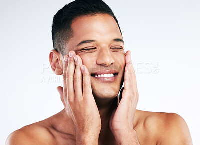 Buy stock photo Face, beauty and skincare with a man grooming in studio on a gray background for health or wellness. Happy, cosmetics and antiaging with a handsome young male touching is soft or smooth skin