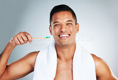 Buy stock photo Mouth, dental and man brushing teeth in studio for hygiene, wellness and grooming against a grey background. Portrait, teeth and oral care by happy guy enjoying fresh, clean and toothpaste routine