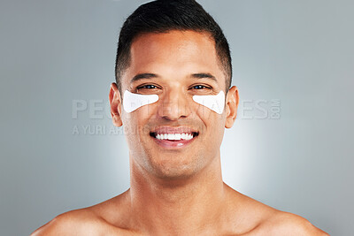 Buy stock photo Happy, beauty and eye patches on a grey studio background. Skincare, health and man model with face and facial cosmetics strip or collagen pads for skin wellness, hydration or facial anti aging