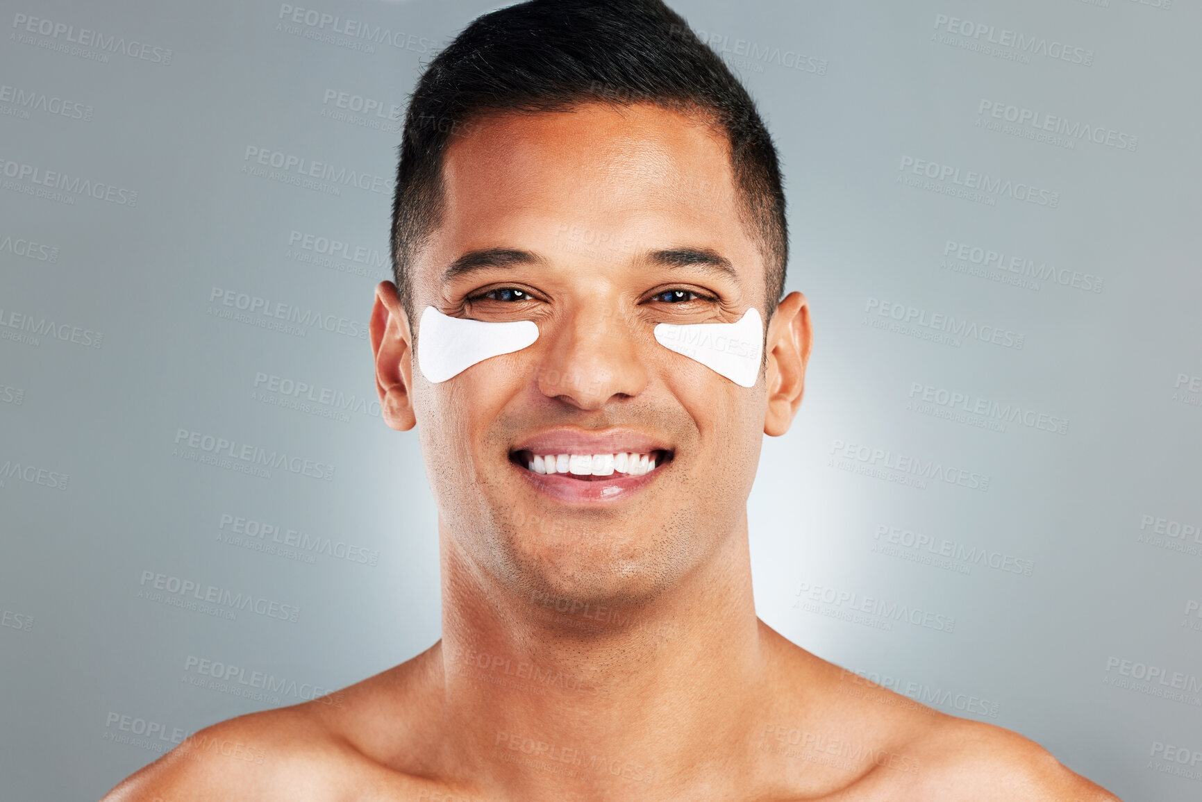 Buy stock photo Happy, beauty and eye patches on a grey studio background. Skincare, health and man model with face and facial cosmetics strip or collagen pads for skin wellness, hydration or facial anti aging