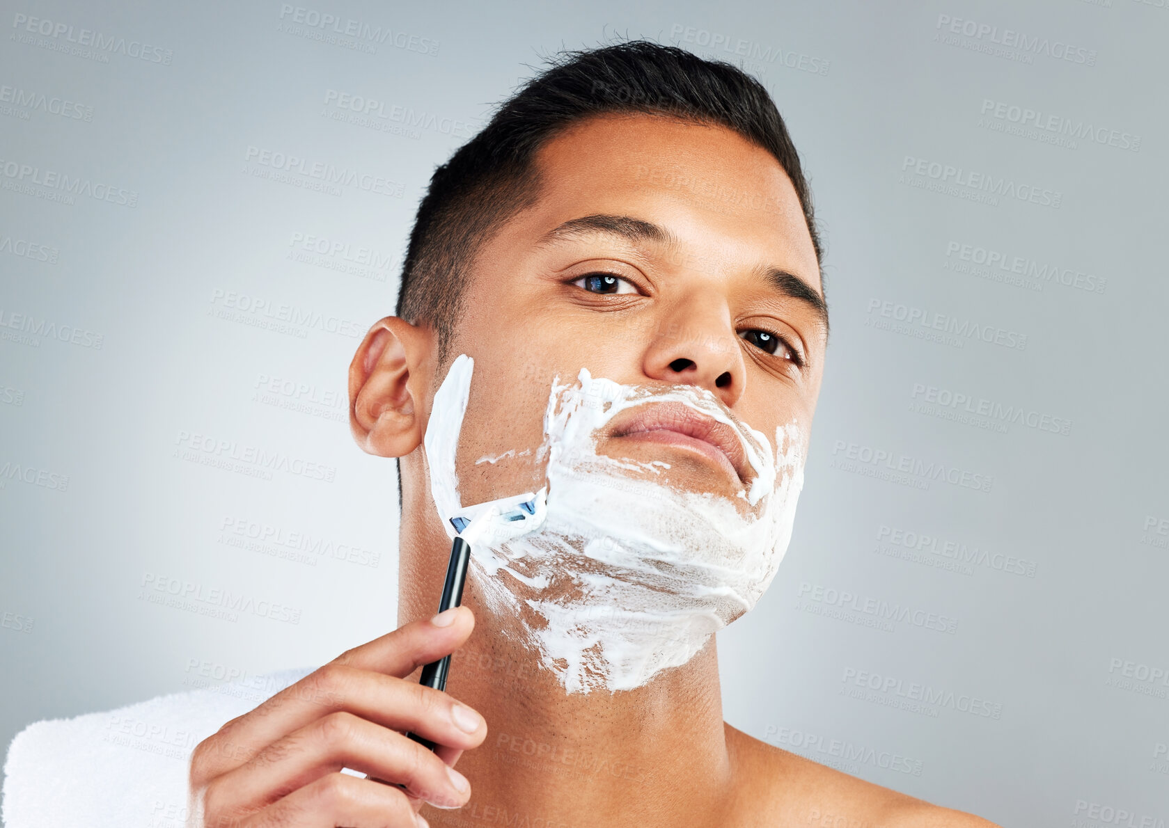 Buy stock photo Man, razor and skincare in beauty for grooming, shave or clean hygiene against a grey studio background. Male face shaving beard with cream, cosmetics and care for healthy or fresh skin