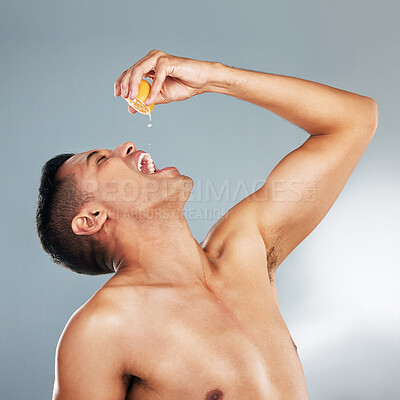 Buy stock photo Health, man and orange fruit for vitamin c for skincare, wellness and immune booster against grey background in studio. Male model, healthy cosmetics and natural beauty for dermatology advertisement