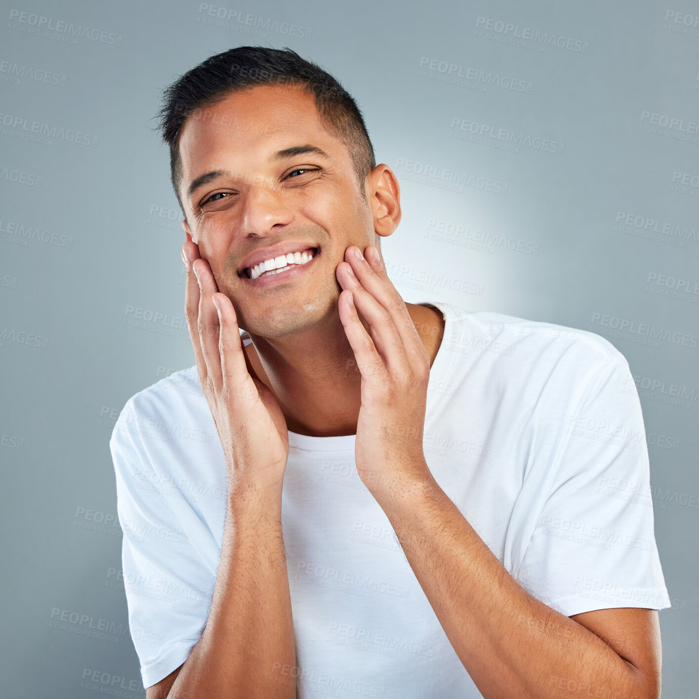 Buy stock photo Man, smile and face with skincare, beauty and dermatology in studio for cleaning, hygiene and healthy skin. Model, happy and hands on cheeks for health, wellness and cosmetics against grey background