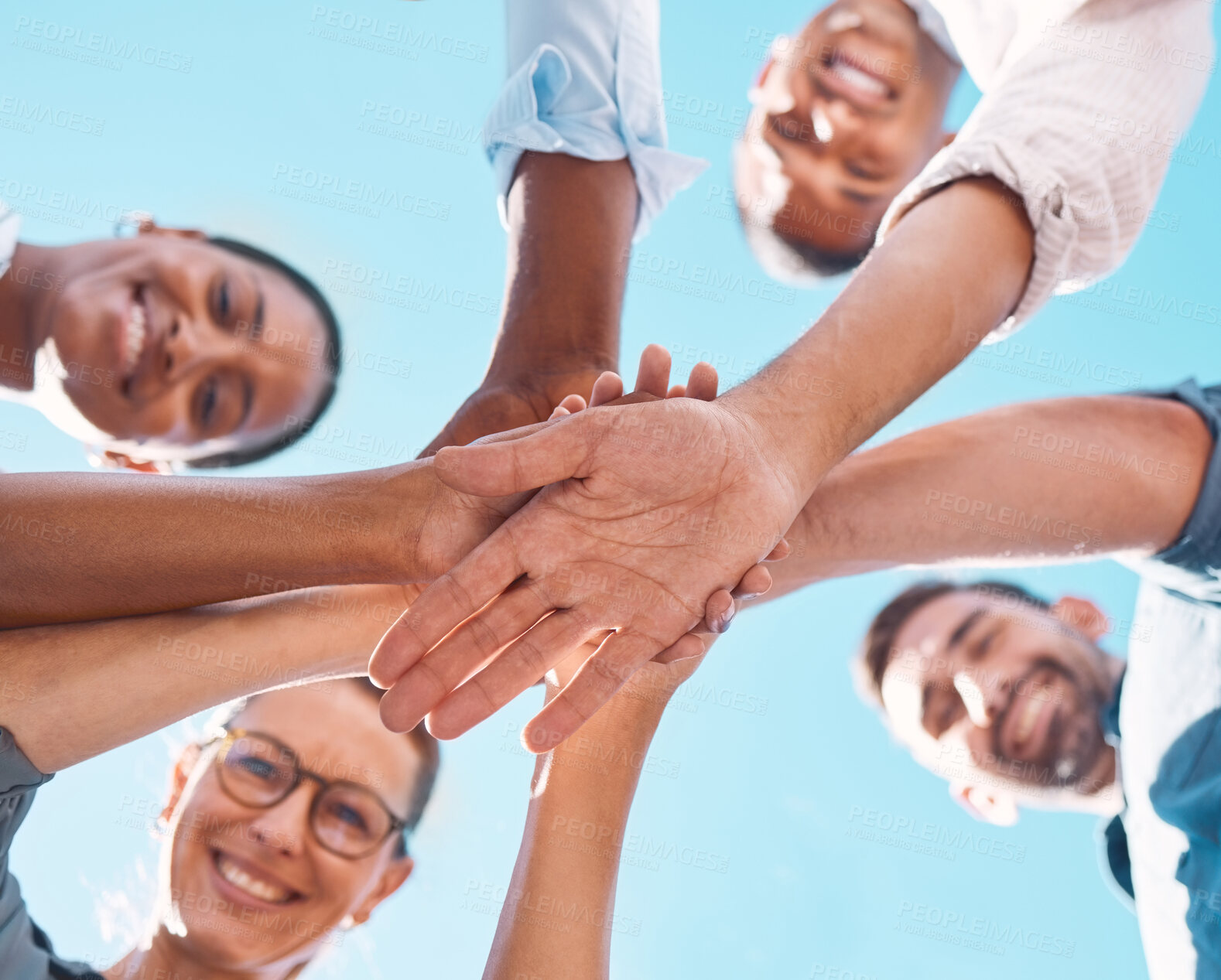 Buy stock photo Hands stacked, support and friends with motivation for collaboration, partnership and community with a blue sky. Low view of people with a goal, celebration and solidarity together in summer