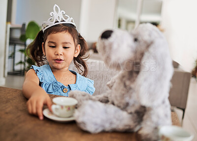 Buy stock photo Girl, toy and tea party at a table with a princess crown, playing, having fun and talking in her home. Fantasy, creative and girl looking happy while talking to a teddy bear and drinking tea together