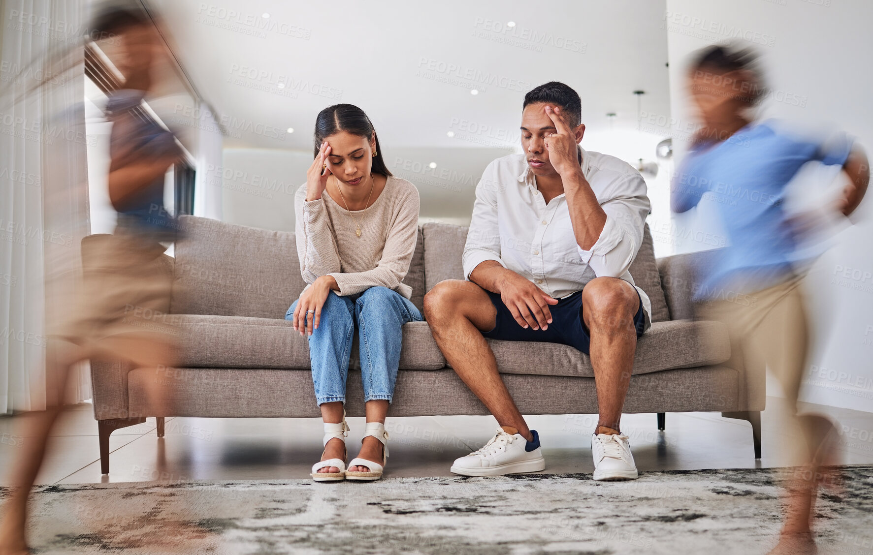 Buy stock photo Headache, kids running and parents on a sofa in a living room, suffering stress, anxiety and adhd children. Family, autism and burnout crisis with woman and man in mental health and energy problem