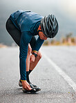 Cycling, man and shoes preparation on road for outdoor sports adventure, triathlon or workout. Fitness, training and athlete cyclist man on street with helmet getting ready for cycle exercise.

