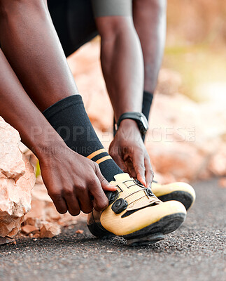 Buy stock photo Black man, cycling shoes and fitness in sports motivation for cardio exercise, training or workout in the outdoors. African American male tying shoe for cycle tour on a road for sport competition