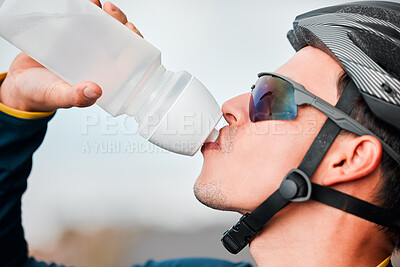 Buy stock photo Fitness, cycling and man drinking water in bottle during a cycle marathon, training or exercise. Cardio, sports and thirsty biker athlete enjoying a refreshing drink, liquid or beverage while biking.