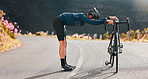 Bike, street cycling and stretching with a sports man at the start of fitness, exercise or training on an asphalt road. Bicycle, stretch and workout with a male cyclist getting ready for a sport ride