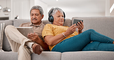 Buy stock photo Senior couple, relax with technology and tablet, smartphone and headphones, streaming and watching online with 5g network. Elderly, man and woman with device, sofa and together in retirement.