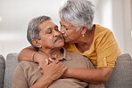 Kiss, love and senior couple in the living room of their house during retirement together. Happy, loving and elderly man and woman with affection, support and help in marriage on the sofa in home