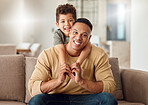 Family, love and trust with a father and son sitting on a sofa in the living room of their home while bonding together. Children, portrait and smile with a young man and boy child in a house to relax