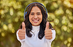 Thumbs up, relax and woman in park with headphones on listening to music on weekend. Freedom, happiness and portrait of student on holiday, vacation and summer break in nature with wireless earphones