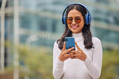 Buy stock photo Phone, woman and music in a city with happy, relax and smiling female walking, texting and chatting online. Radio, podcast and audio streaming with trendy lady enjoying subscription service in town